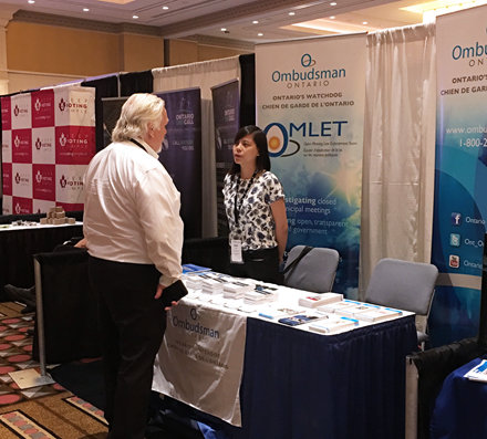 A conference attendee visiting the Ombudsman Ontario booth during the Association of Municipalities of Ontario conference.