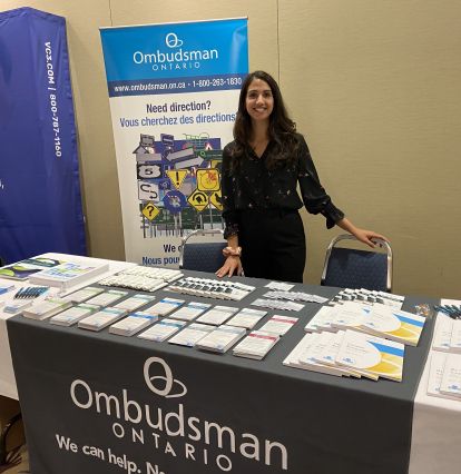 Staff person standing behind table of promotional materials