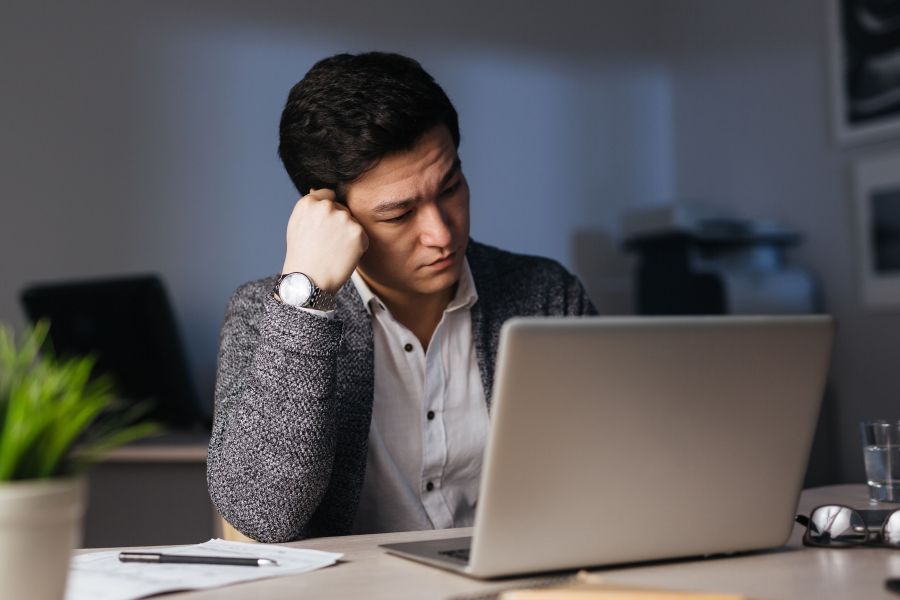 Man sitting in front of laptop at office  Man sitting in front of laptop at office