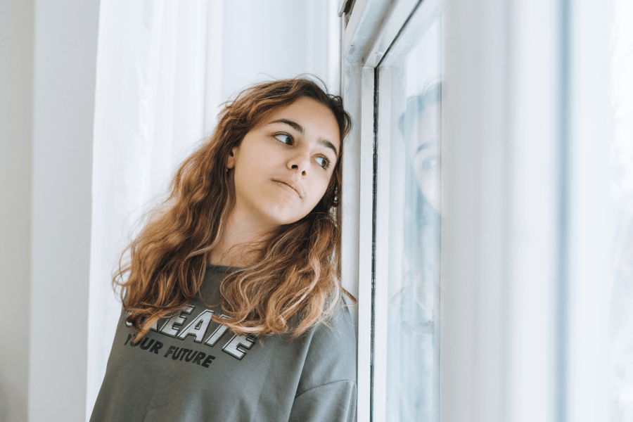 Un jeune regardant par la fenêtre Un jeune regardant par la fenêtre