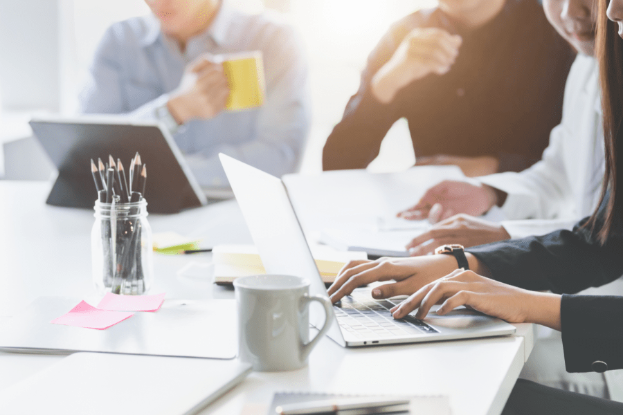  Des travailleurs autour d'un bureau avec des ordinateurs