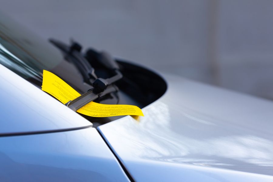Ticket de stationnement jaune sur le pare-brise de la voiture Ticket de stationnement jaune sur le pare-brise de la voiture